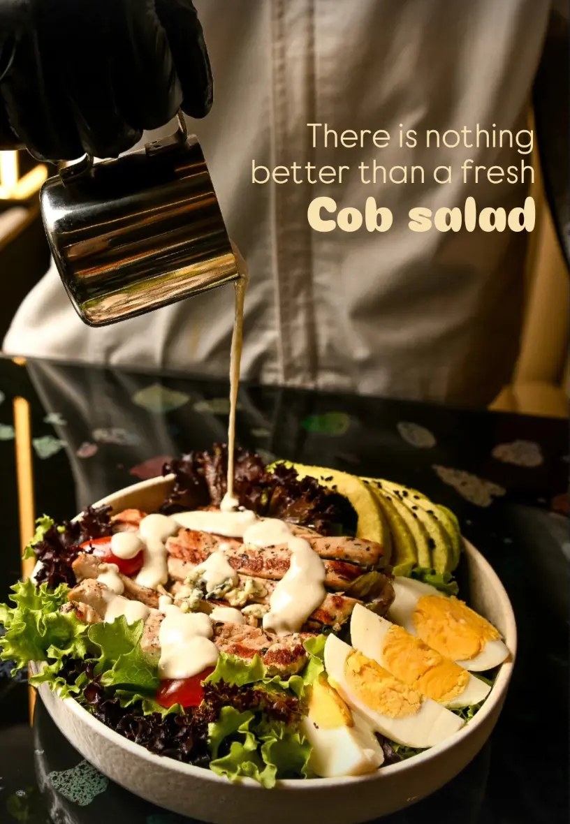 Cobb salad with dressing being poured